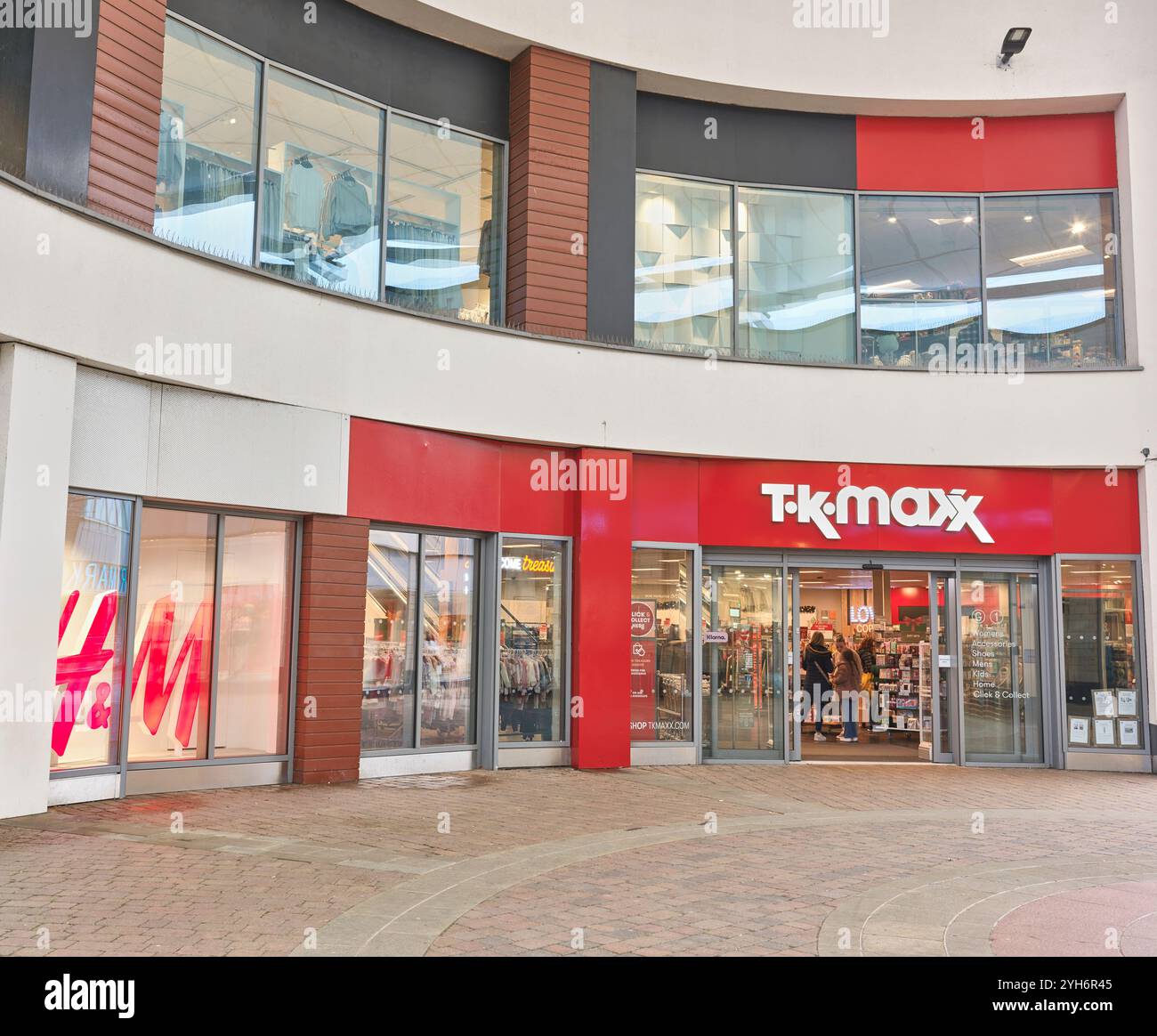 T K Max et H & M Shops sid-by-side dans le quartier commerçant de Corby, en Angleterre. Banque D'Images