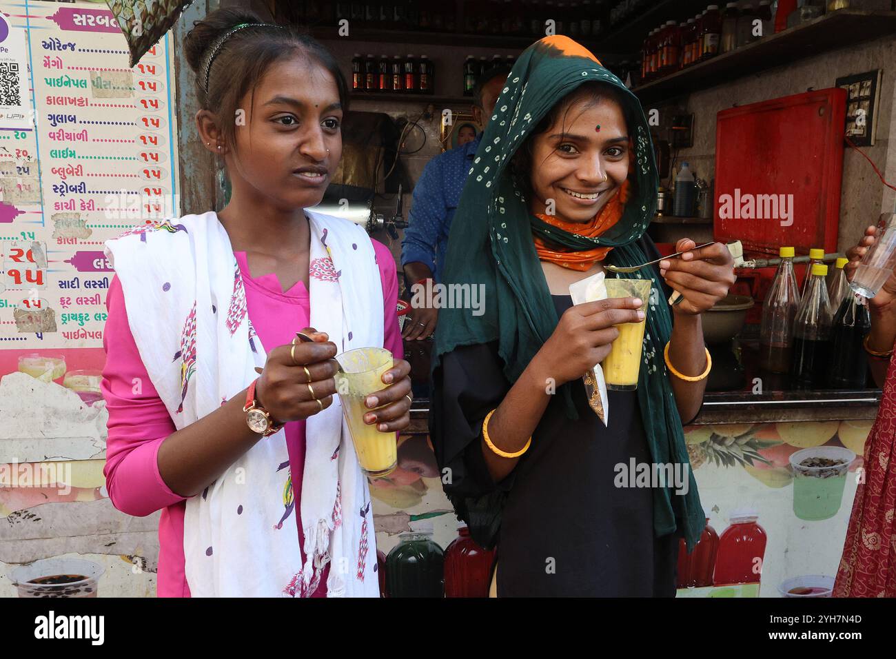 Filles buvant des lassi aromatisés aux fruits à Rajkot, Gujarat, Inde Banque D'Images