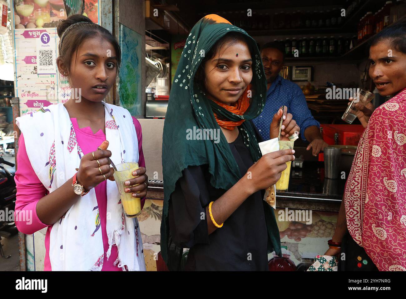 Filles buvant des lassi aromatisés aux fruits à Rajkot, Gujarat, Inde Banque D'Images