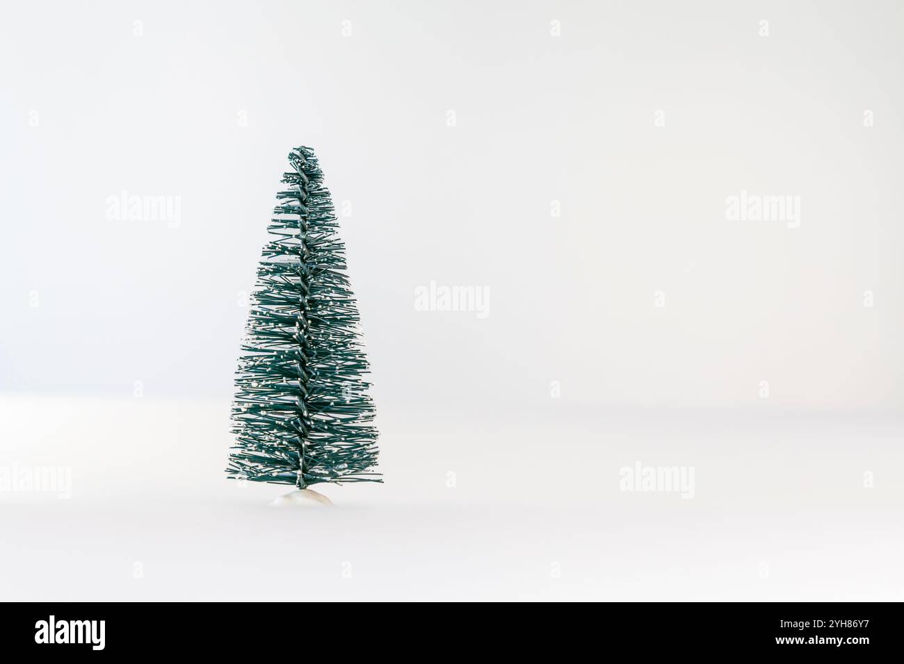 Petit arbre de Noël vert artificiel sur fond blanc. Concept de Noël et nouvel an. Banque D'Images