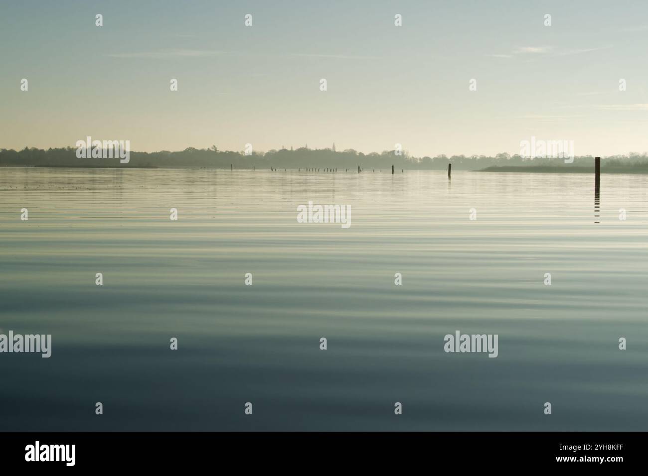 Des bornes de marquage de chenal dans les eaux calmes d'hiver de fin d'après-midi de Barton Broad, Norfolk, Broads National Park Banque D'Images