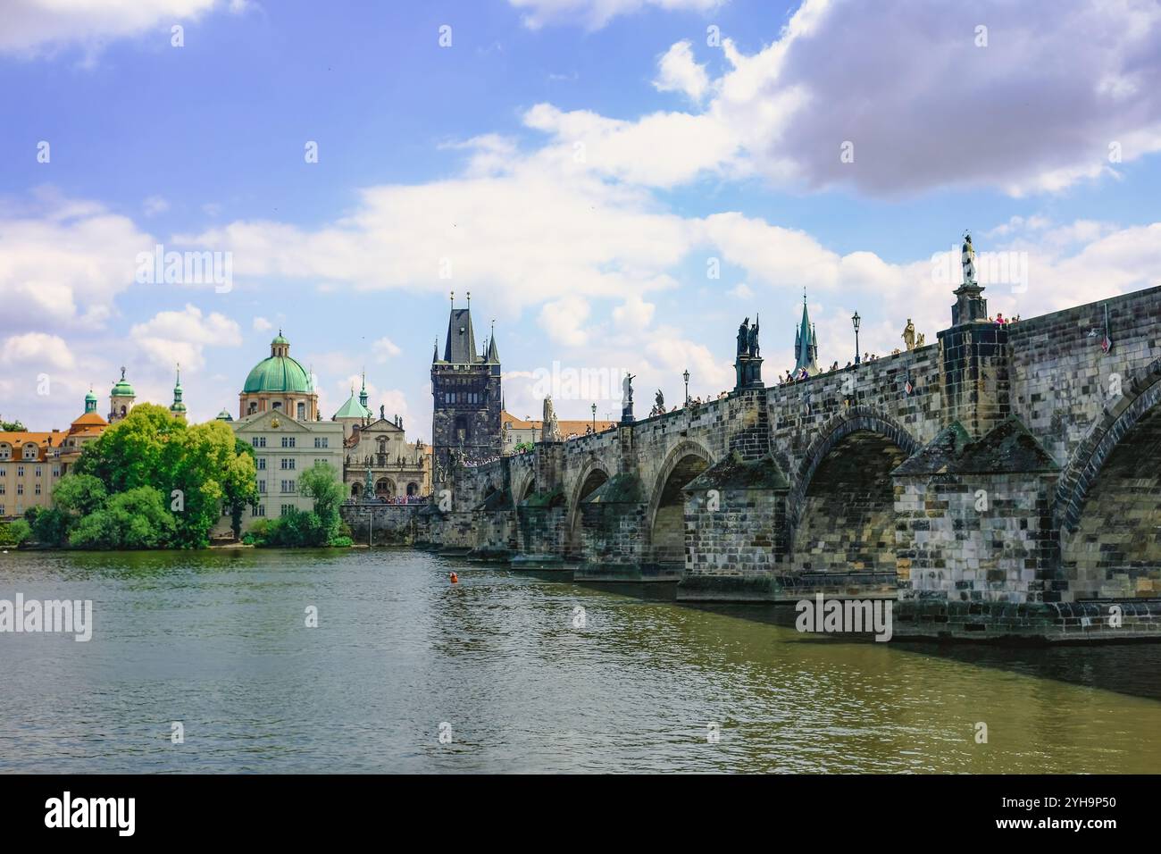Le pont Charles s'étend sur la rivière Vltava à Prague, avec des statues en pierre ornées, avec des touristes se promenant sur toute sa longueur. Banque D'Images