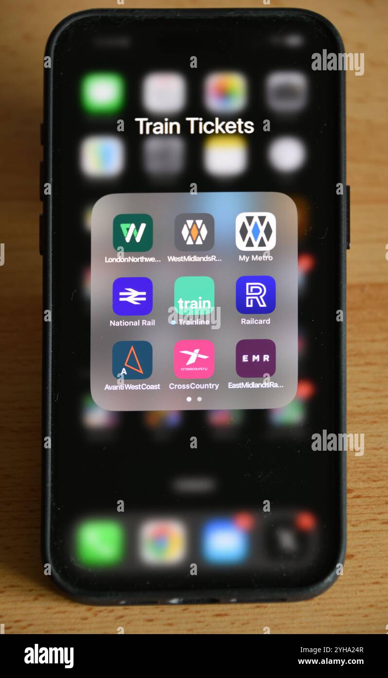 UK smartphone sur la table avec des applications de billets de train dans un dossier pour les compagnies d'exploitation de train, National Rail, Railcard et le Trainline.com Banque D'Images