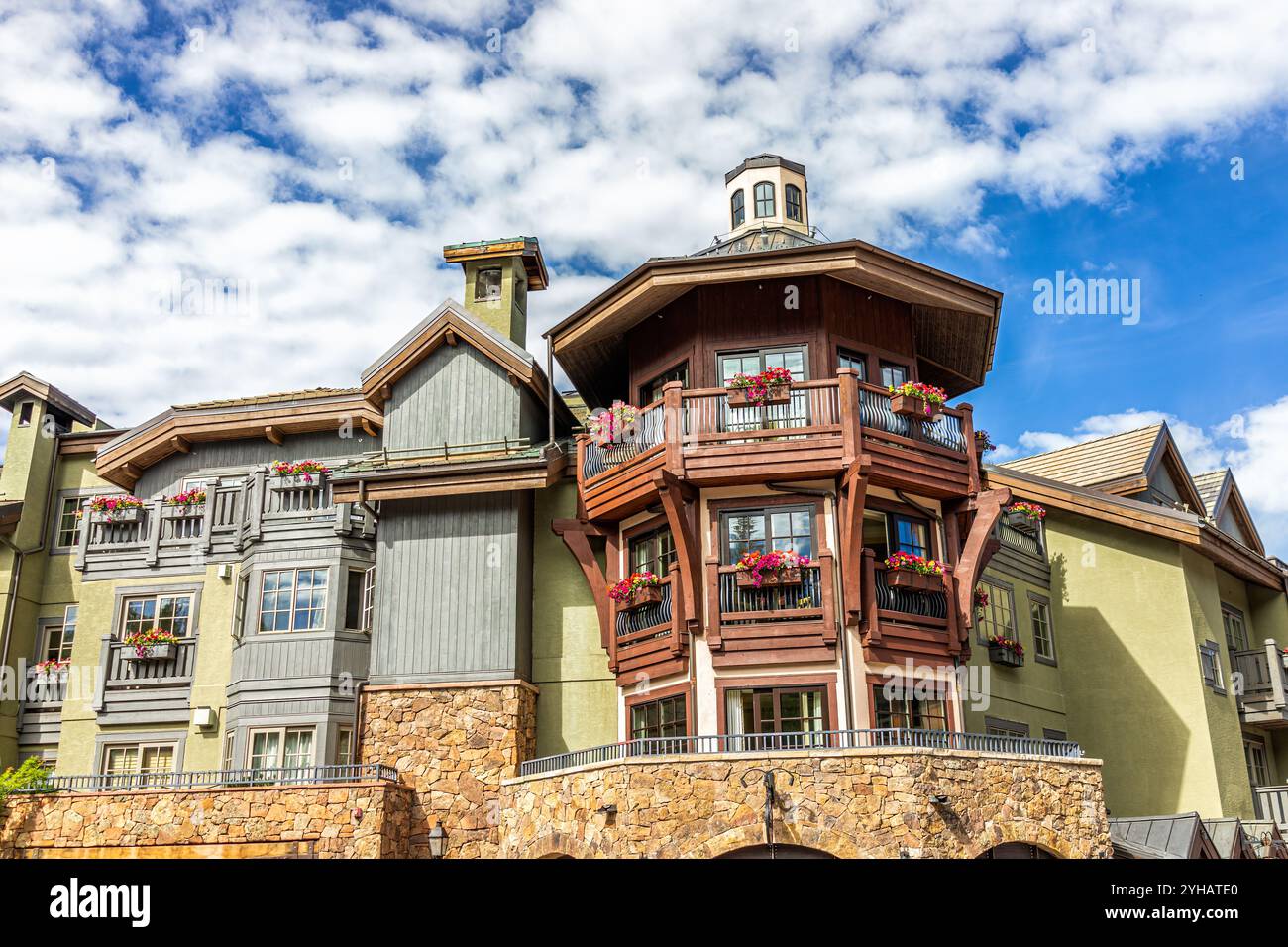 Vail, Colorado extérieur de l'appartement d'architecture européenne suisse avec fenêtres et décorations de fleurs, nuages de ciel bleu Banque D'Images