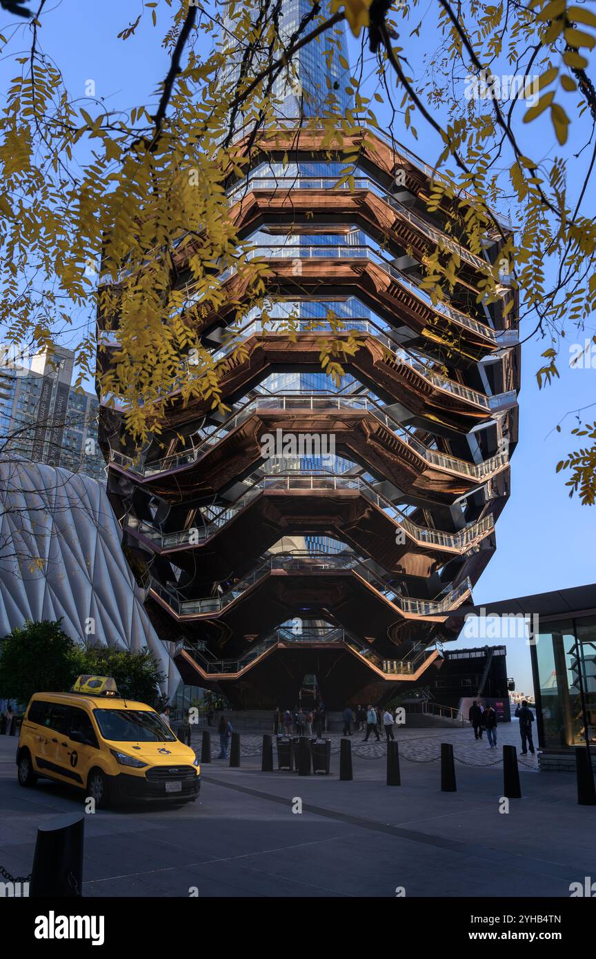 Taxi jaune passant devant le navire à Hudson Yards Manhattan encadré de feuilles d'automne, New York, États-Unis. Banque D'Images