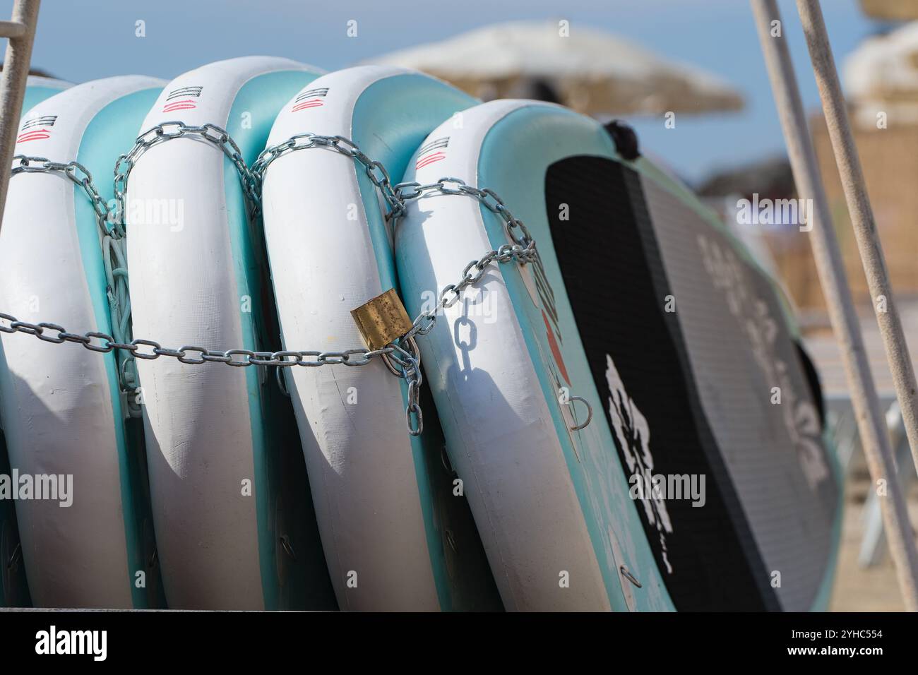 Paddleboards dans un magasin de location attaché avec une chaîne et une serrure à Piombino, Italie le 3 juillet 2024. (CTK photo/Petr Malina) Banque D'Images