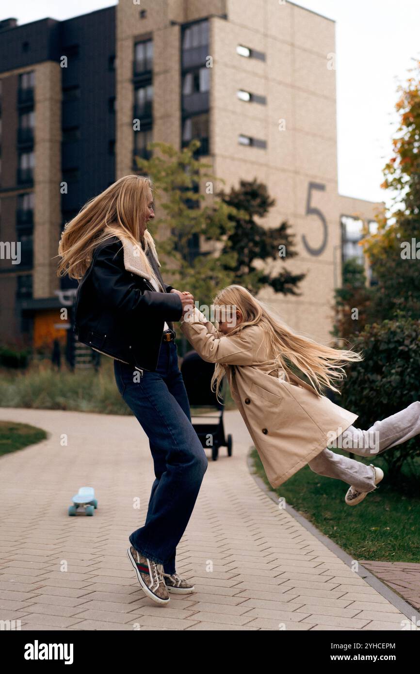 Maman et fille skateboard dans un parc de la ville Banque D'Images