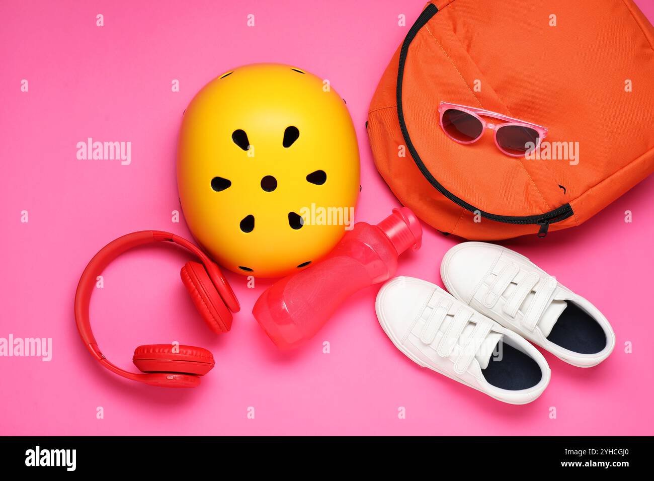 Casque de vélo, accessoires et baskets sur fond rose, pose à plat Banque D'Images