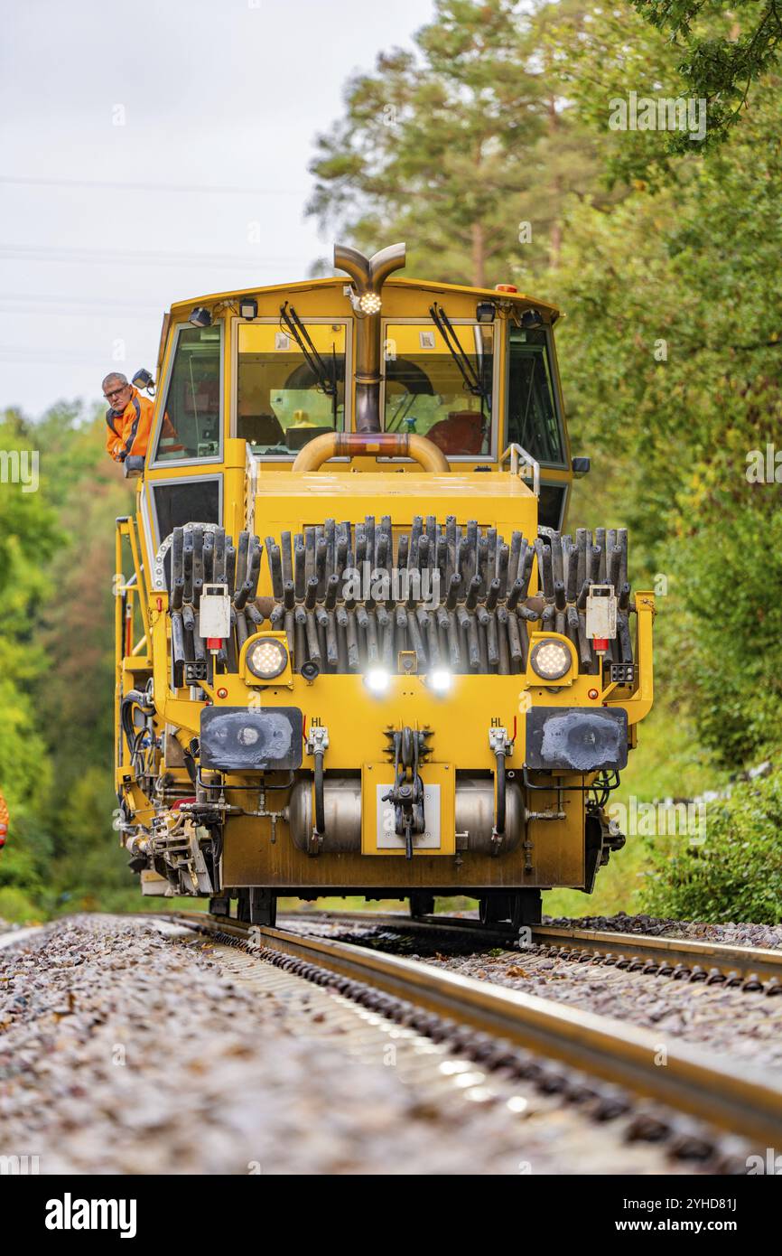 Machine de travail ferroviaire sur des voies avec des ouvriers debout autour, construction de voies Hermann Hesse Bahn, district de Calw, Forêt Noire, Allemagne, Europe Banque D'Images