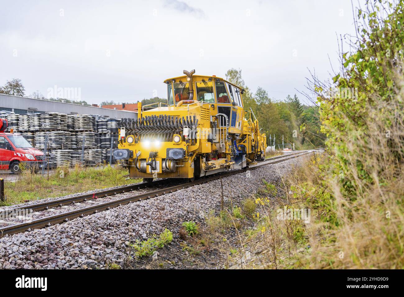 Véhicule ferroviaire sur rails en environnement industriel avec ciel nuageux, machine de bourrage, Hermann Hessebahn, Calw, Forêt Noire, Allemagne, Europe Banque D'Images