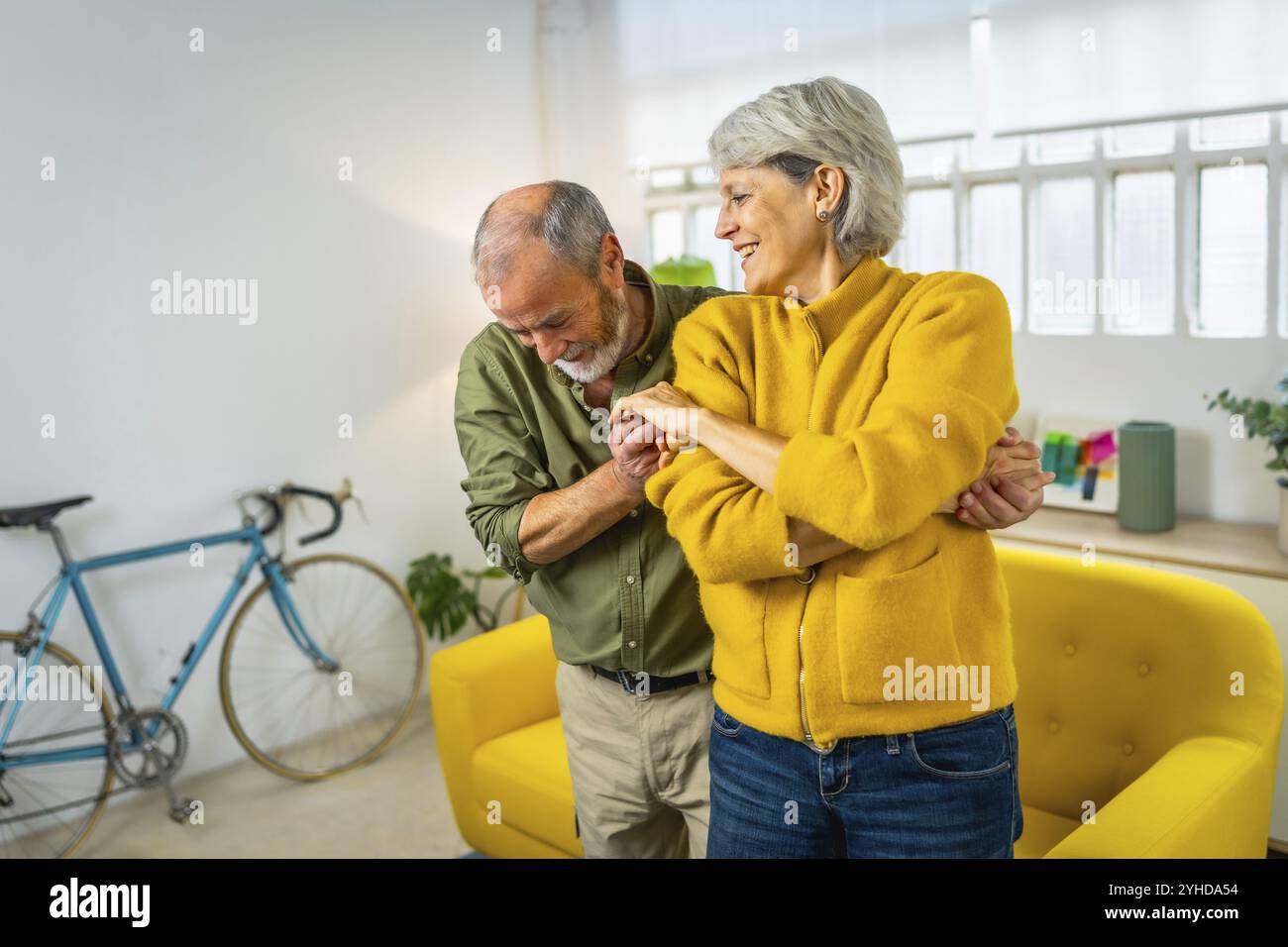 Heureux couple mature dansant ensemble et souriant à la maison Banque D'Images