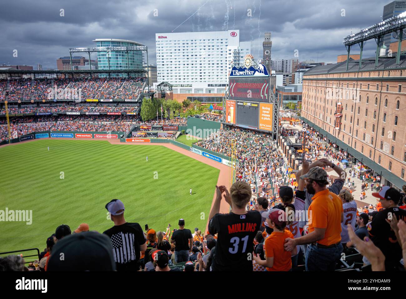 Match de baseball au Oriole Park At Camden Yards à Baltimore | BALTIMORE, Maryland — Un match de baseball se déroule au Oriole Park At Camden Yards, le terrain maison des Baltimore Orioles. Le stade, inauguré en 1992, a établi le standard pour la conception rétro-classique des stades de la Major League Baseball. L’entrepôt emblématique B&O sert de toile de fond pour le champ droit du stade. Banque D'Images