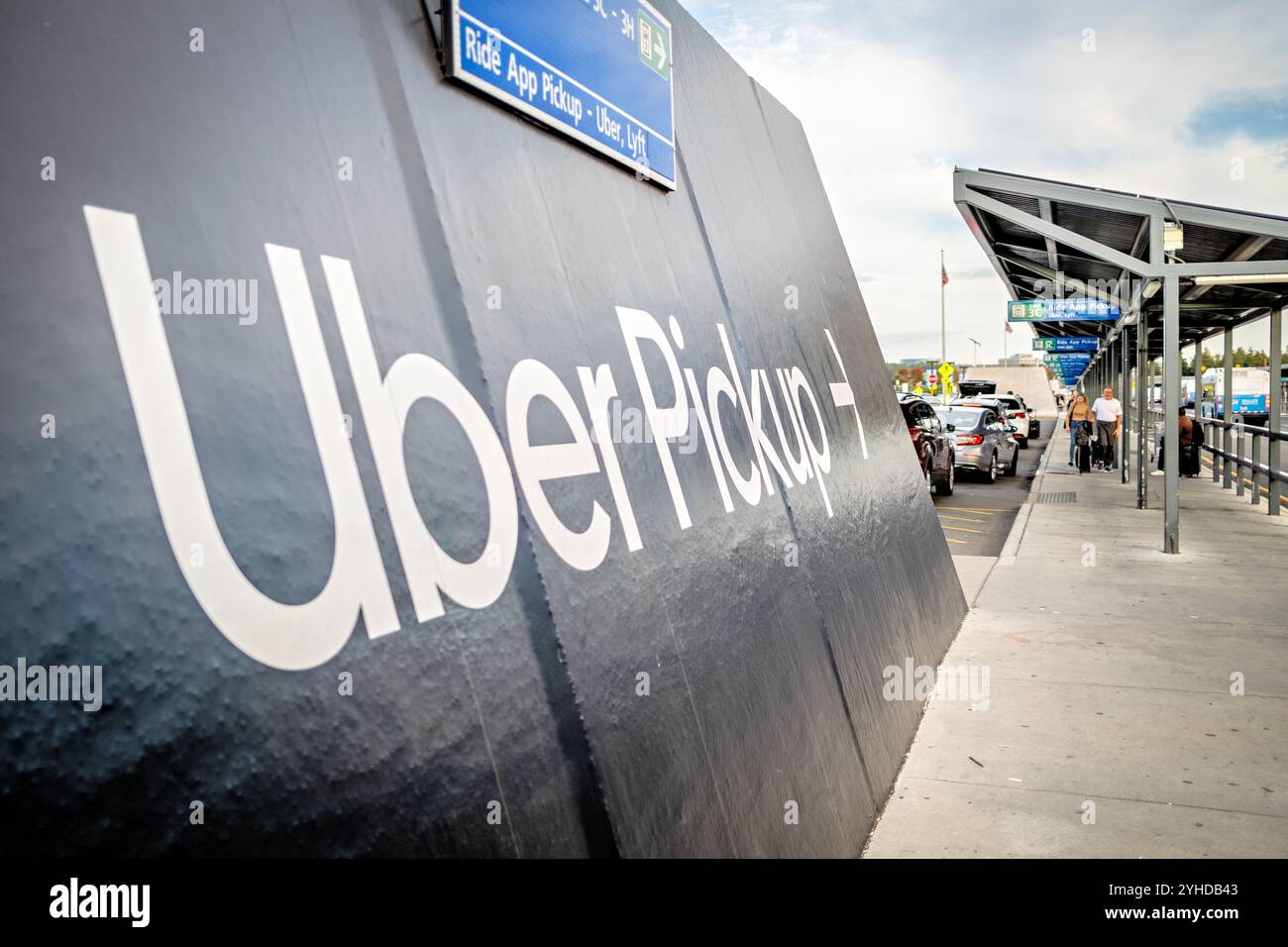 Uber Lyft covoiturage Aéroport de Dulles Virginie // DULLES, Virginie — Une zone désignée de prise en charge covoiturage dessert les passagers arrivant en utilisant Uber, Lyft et d'autres services de covoiturage à l'aéroport international de Washington Dulles. Un panneau d'orientation clair guide les voyageurs vers les zones de chargement dédiées situées au niveau du transport terrestre. Le système de ramassage organisé permet de gérer le flux de trafic et de faciliter les correspondances passagers efficaces à cette importante passerelle internationale desservant la région métropolitaine de Washington D.C. L'aéroport de Dulles, ouvert en 1962, est l'un des trois principaux aéroports desservant Banque D'Images