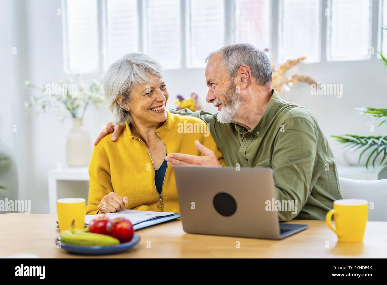 Heureuse femme senior recevant de bonnes nouvelles avec notification en ligne et son mari la félicitent Banque D'Images