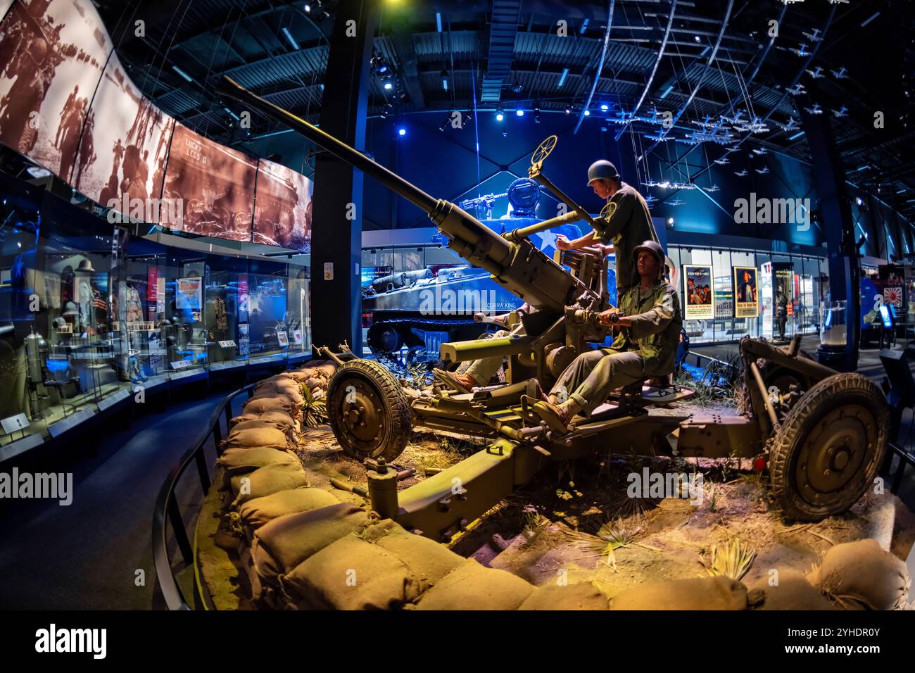 Canon anti-aérien M1 Bofors Musée National de l'Armée des États-Unis Fort Belvoir Virginie | FORT BELVOIR, Va. — Des figurines en fonte manœuvrent un canon anti-aérien M1 Bofors de 40 mm dans un diorama du théâtre du Pacifique au Musée National de l'Armée des États-Unis, avec le char Sherman « Cobra King » visible en arrière-plan. Cette arme suédoise, adoptée par l'armée américaine en 1941, est devenue l'un des canons anti-aériens les plus utilisés de la Seconde Guerre mondiale. Des emplacements sacrés de sable et des affiches de propagande d'époque complètent le décor du front. Banque D'Images