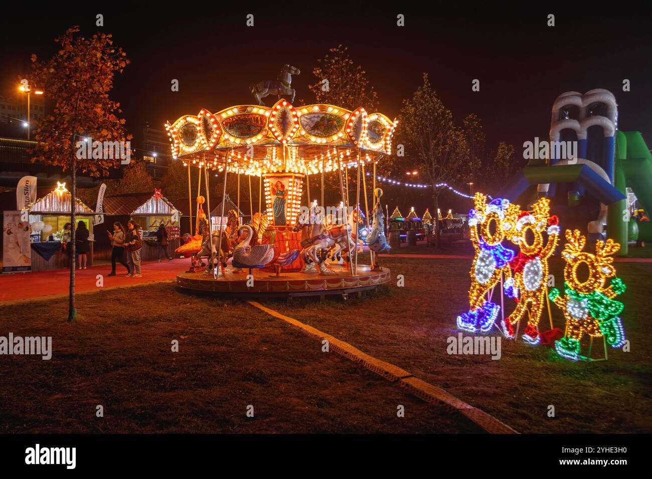 Coimbra, Portugal - 21 novembre 2023 : carrousel parisien pour enfants illuminé la nuit à Magic Land à Coimbra, Portugal. Banque D'Images