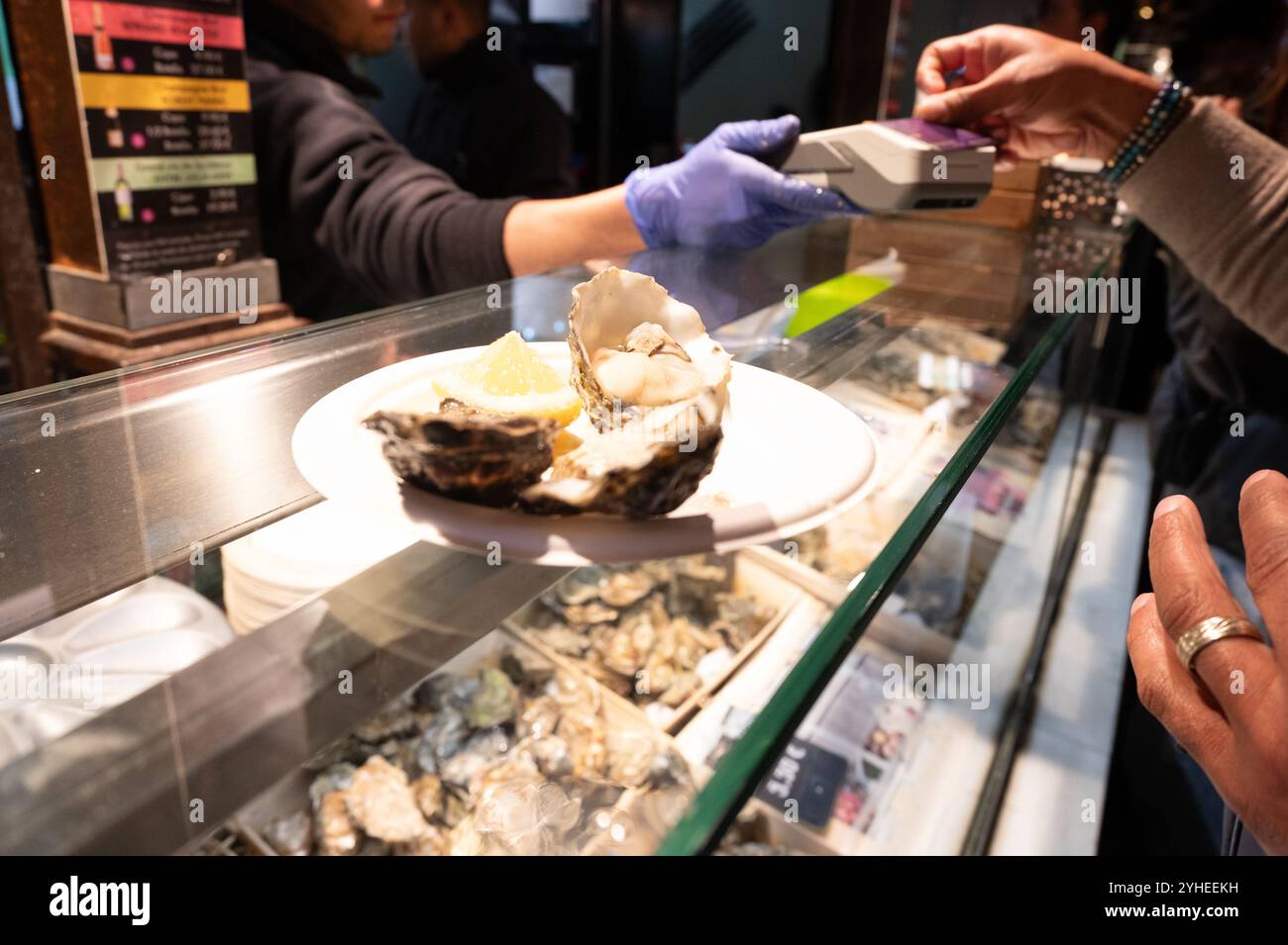Un plateau de fruits de mer fraîchement écaillé servi avec du citron, capturé lors d'une transaction de marché mettant en vedette des expériences culinaires authentiques. Banque D'Images
