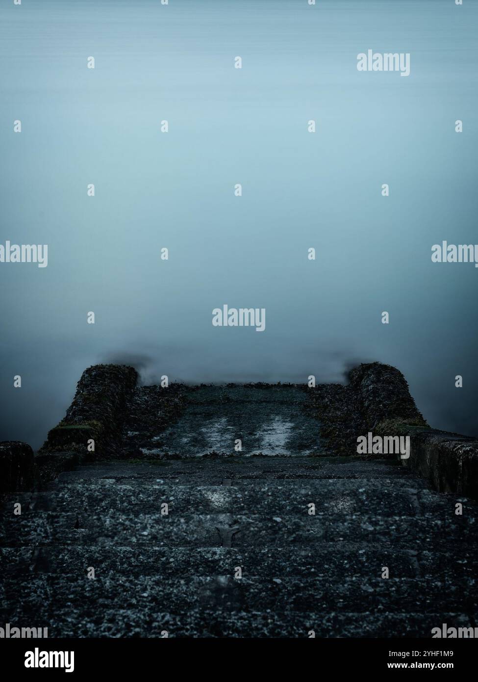 Moody plan de longue durée de marches en béton menant à la mer avec espace de copie pour une utilisation comme arrière-plan Banque D'Images