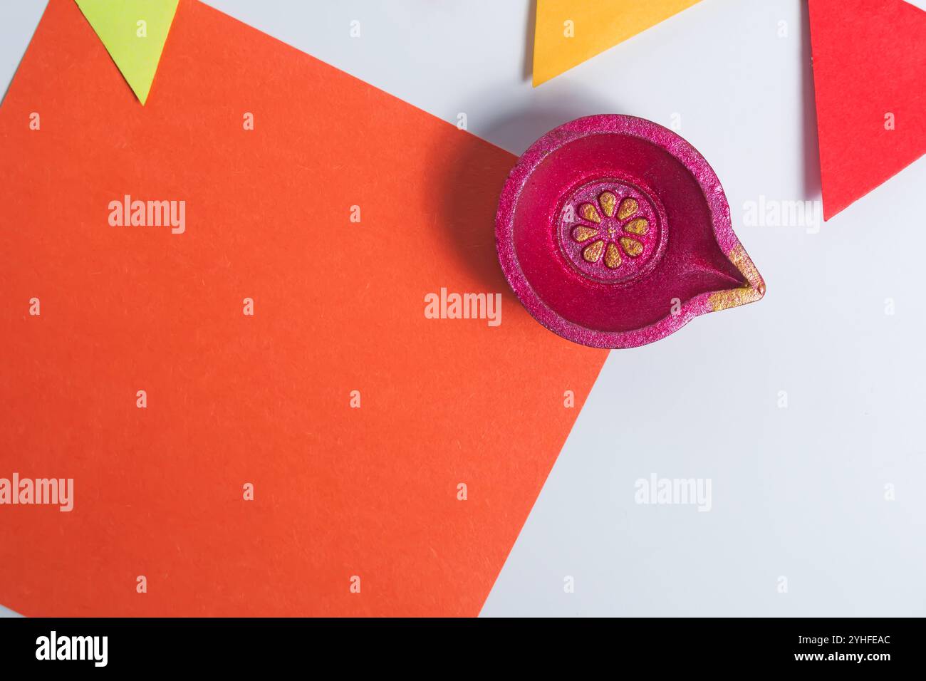 Une note de papier orange vif avec diya et drapeau décoratif sur fond blanc. Idéal pour les cartes de voeux Diwali, invitations, décorations de vacances. Banque D'Images