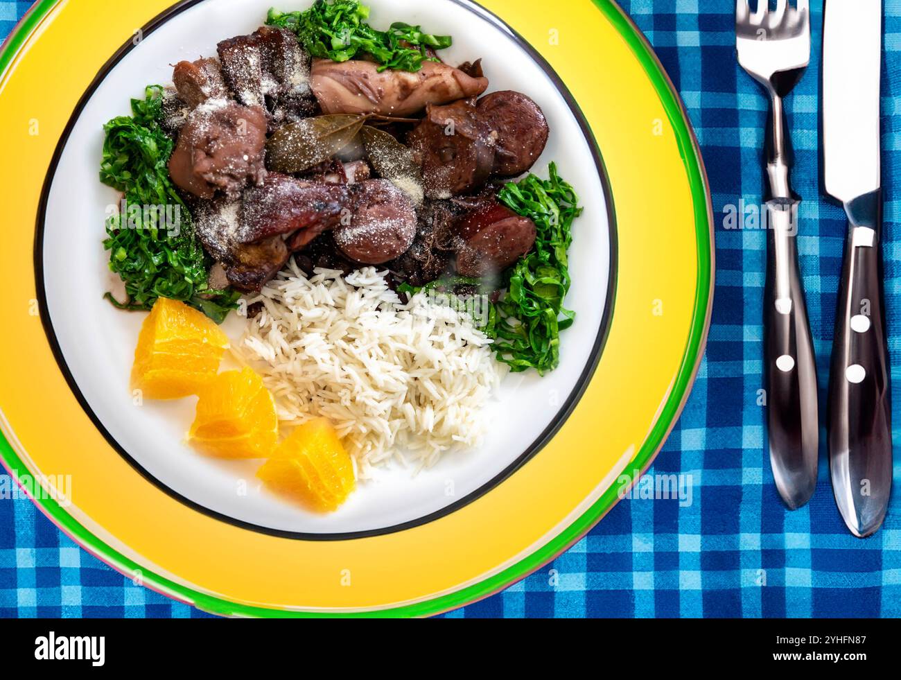 La meilleure et la plus traditionnelle feijoada brésilienne dans le monde servie sur une assiette verte et jaune Banque D'Images