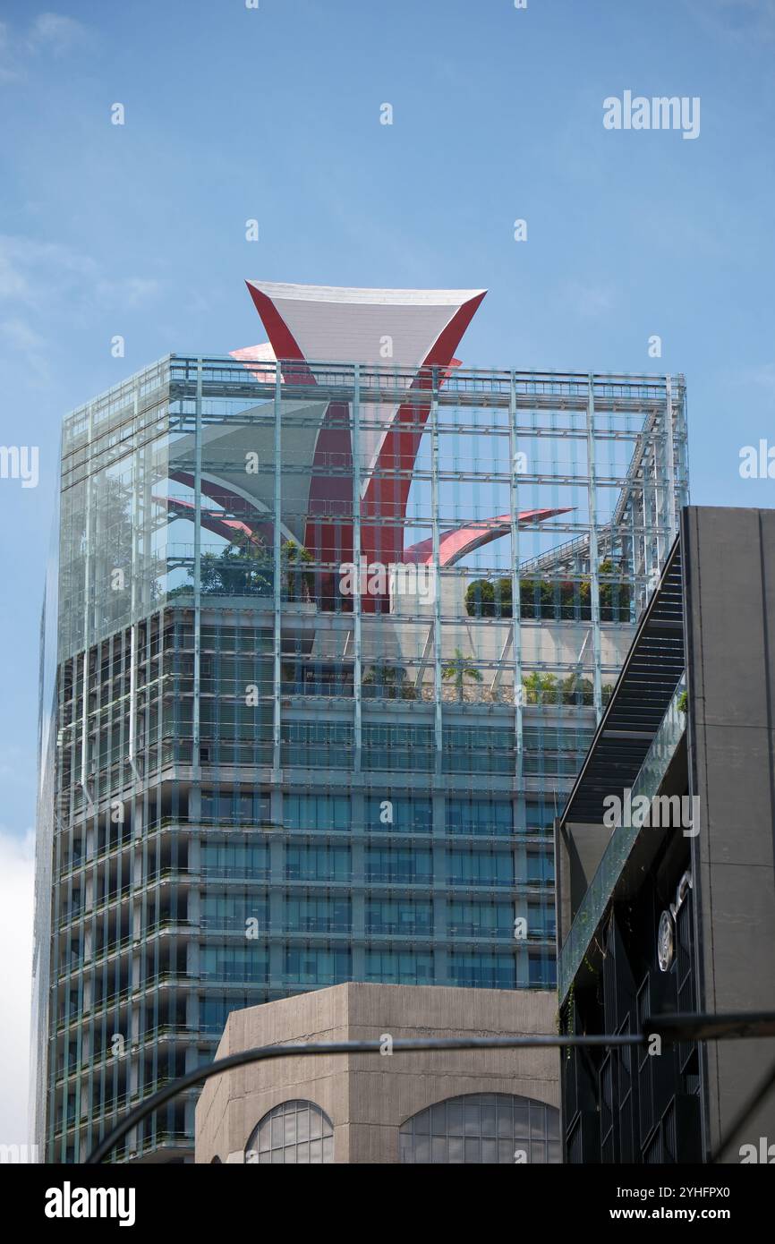 Situé au cœur du quartier des affaires de Singapour, CapitaGreen est un monument emblématique avec une couronne d'entonnoir cramoisi à pétales posée sur son toit Banque D'Images