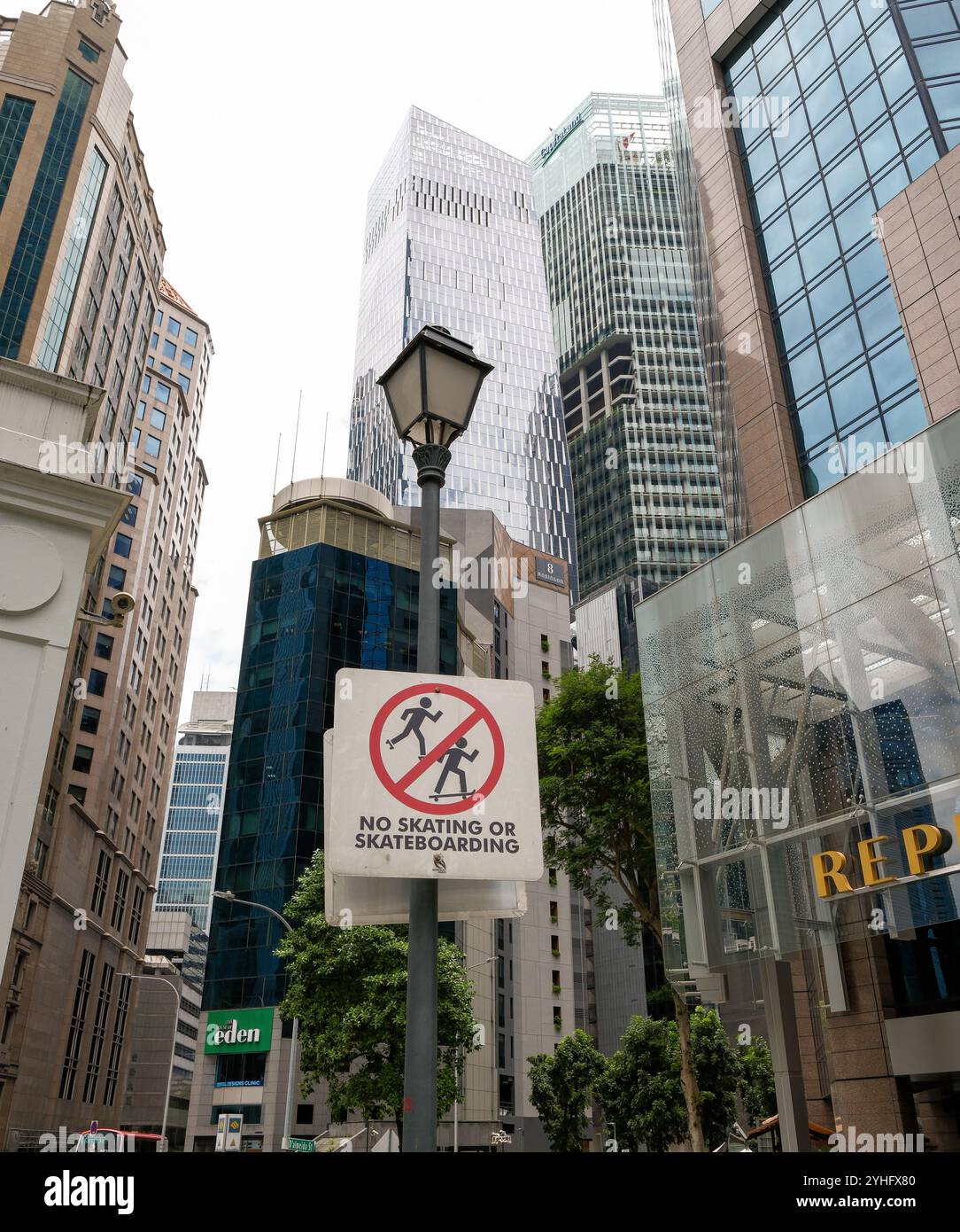 Aucun panneau d'avertissement de patinage ou de skateboard accroché à un lampadaire dans le quartier financier de la ville de Singapour parmi les gratte-ciel. Banque D'Images