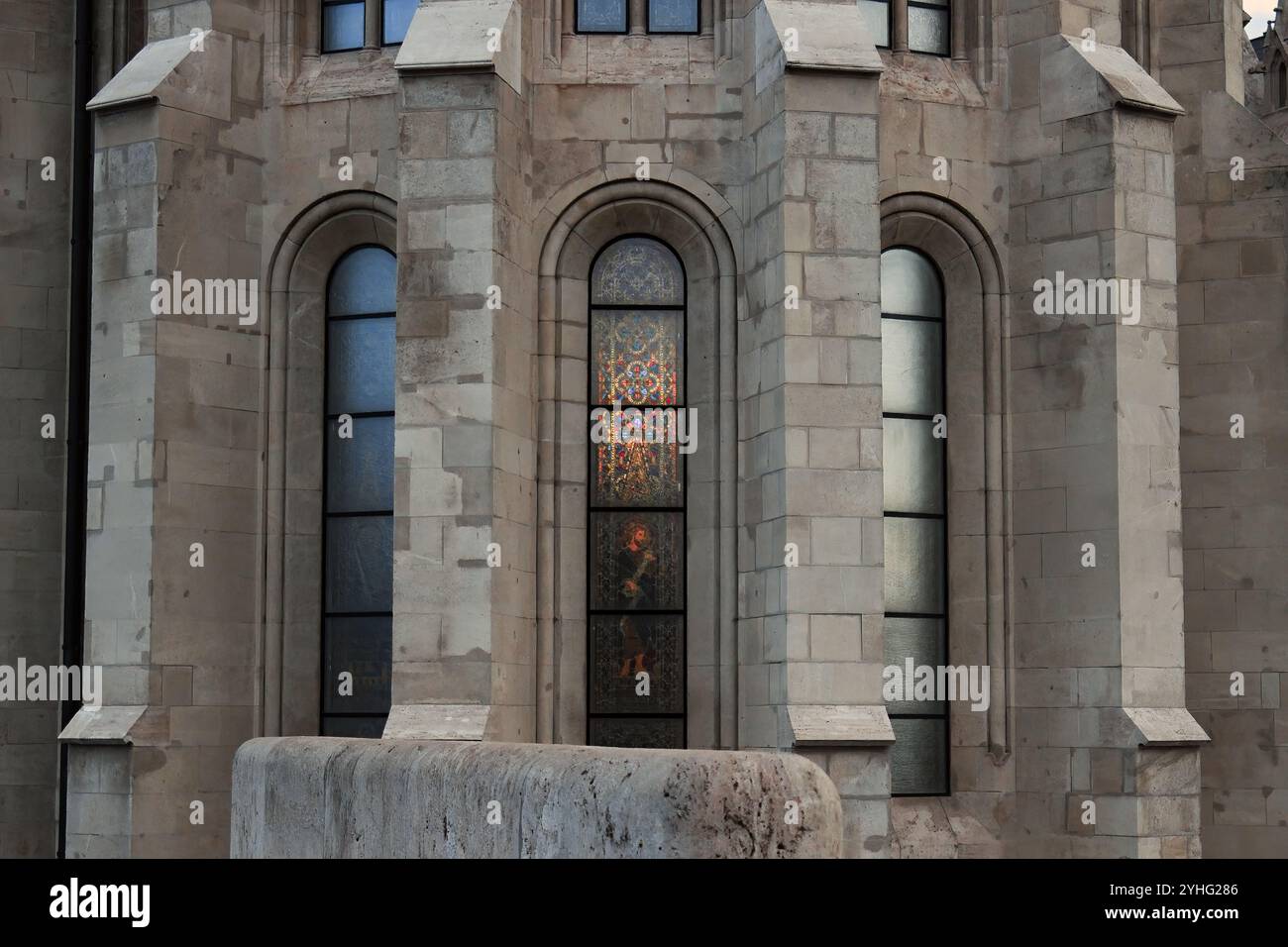 Une vue rapprochée de vitraux sur la façade d'une église, avec des motifs complexes reflétant sur la surface du bâtiment. Banque D'Images