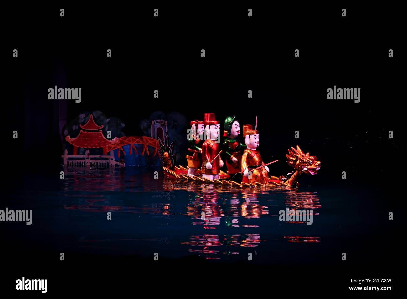 Les marionnettes d'eau vietnamiennes traditionnelles exécutent une scène avec un bateau-dragon, symbolisant la riche culture et le folklore du Vietnam. Banque D'Images