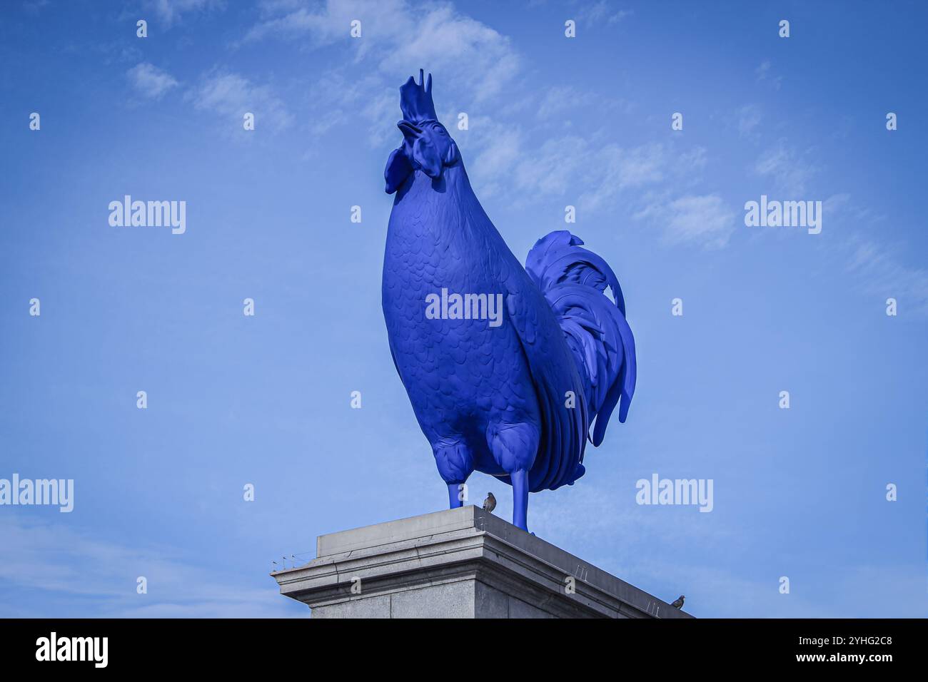 Statue de coq bleu éclatant contre un ciel clair, symbolisant l'art audacieux et la sculpture moderne dans les espaces publics. Banque D'Images