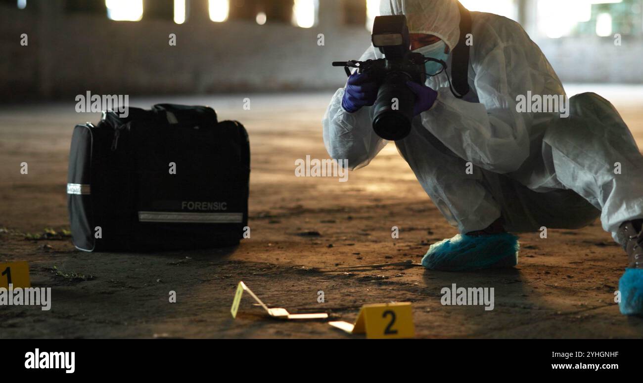 Crime, personne et photographie sur place pour enquête, documentation et preuves dans un entrepôt abandonné. Médecin légiste, EPI ou caméra Banque D'Images