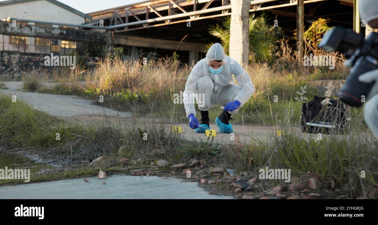 Scène de crime, les gens et l'extérieur avec équipement pour la criminalistique, les preuves et l'enquête. Équipe, costume Hazmat ou photographie dans le champ pour inspection Banque D'Images