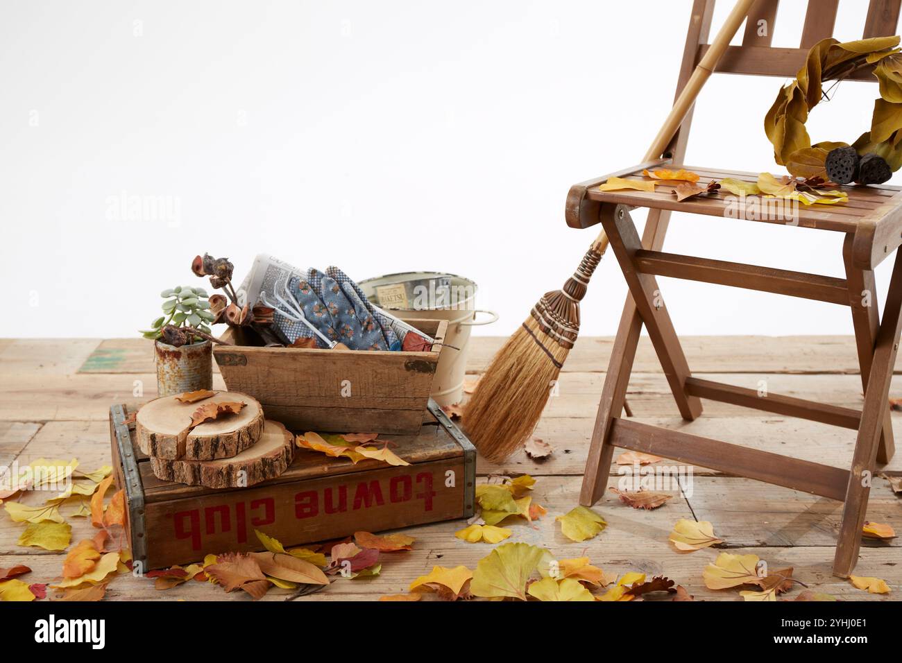 Chaise en bois sur le pont avec feuilles mortes et balai Banque D'Images