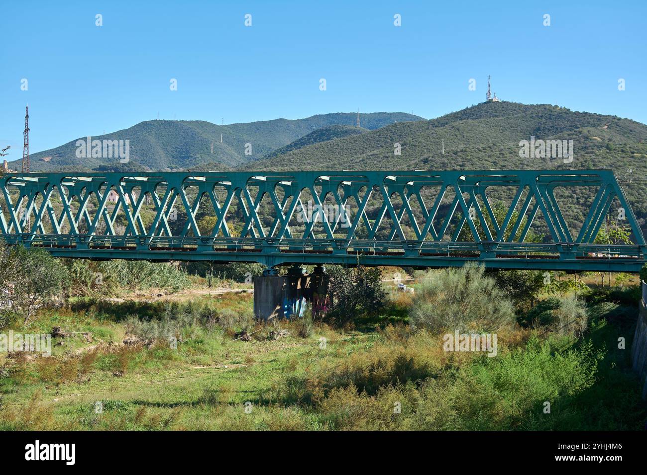 Montcada i Reixac. Espagne - 12 novembre 2024 : vue panoramique sur un pont en treillis vert en acier traversant la rivière Ripoll, encadré par une végétation verdoyante et une végétation verdoyante Banque D'Images