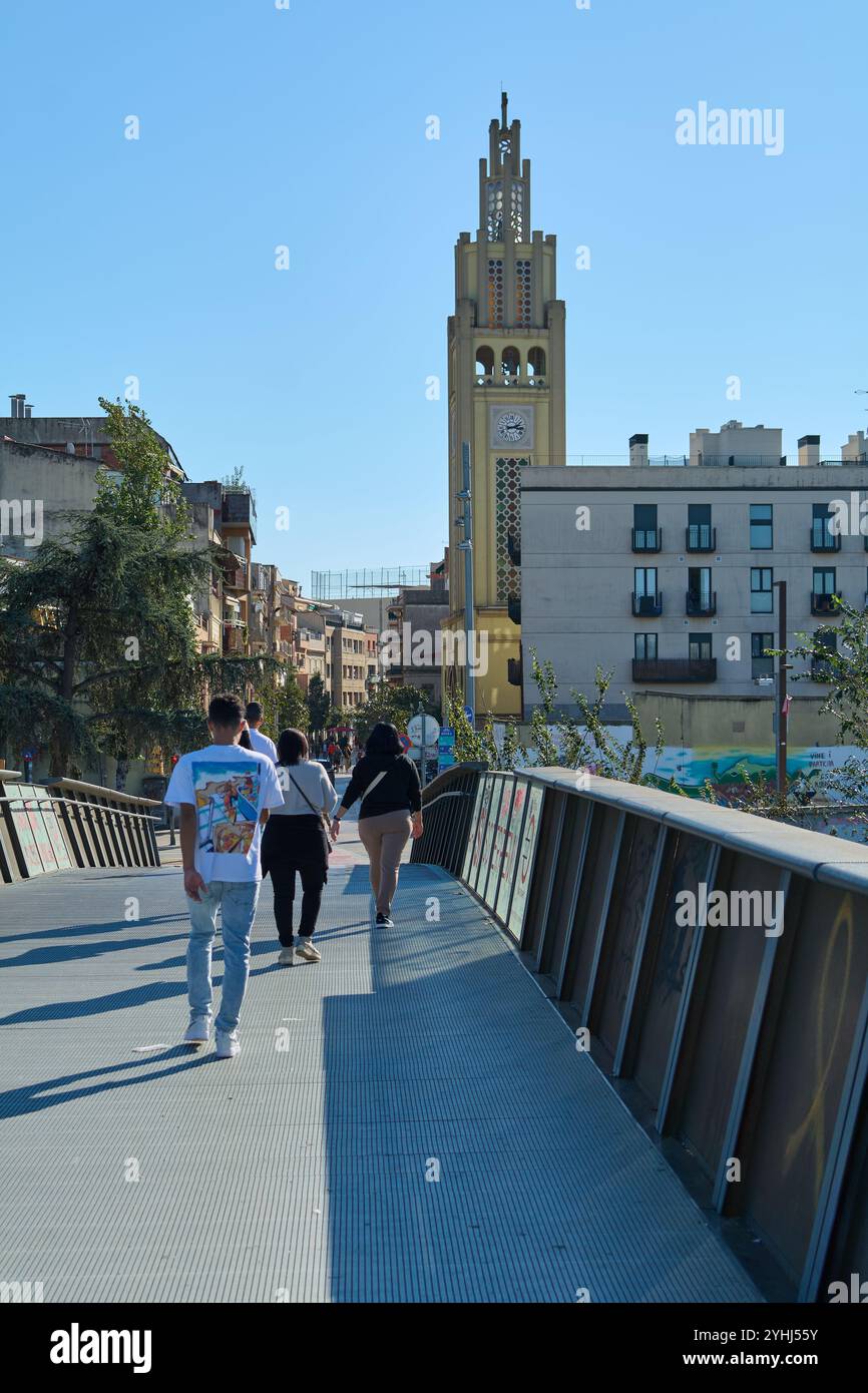 Montcada i Reixac. Espagne - 12 novembre 2024 : la passerelle de Moncada et Reixac enjambe la rivière Ripoll, avec des piétons traversant, fournissant un Banque D'Images