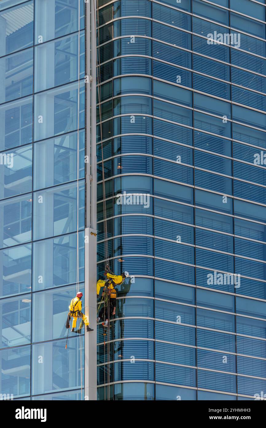 Deux nettoyeurs de vitres travaillant sur un immeuble en verre de grande hauteur à Capetown Banque D'Images
