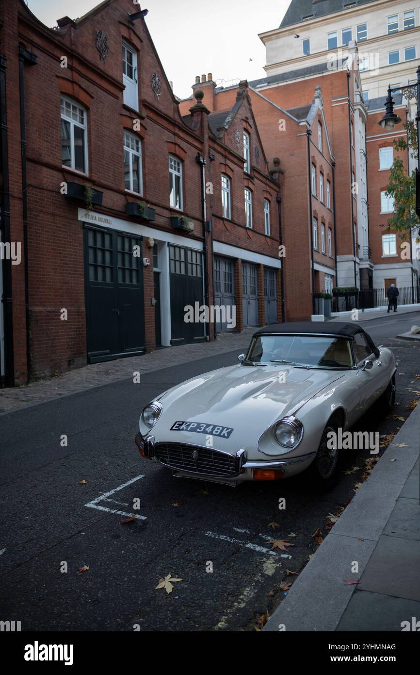 Voiture anglaise classique de type E Jaguar garée dans une rue arrière au cœur du quartier de Mayfair à Londres, l'un des quartiers les plus riches de la capitale, Angleterre. Banque D'Images