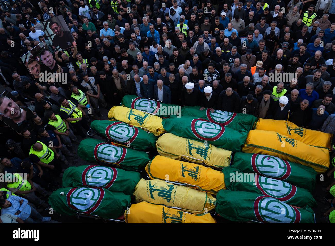 (NOTE DE LA RÉDACTION : image représente la mort) une foule immense rend hommage aux cadavres enveloppés dans le drapeau du mouvement Hezbollah et Amal pendant le cortège funèbre à Tyr. Les funérailles de huit ambulanciers paramédicaux et de deux civils ont eu lieu après qu'ils eurent été tués lors d'une frappe israélienne. Banque D'Images