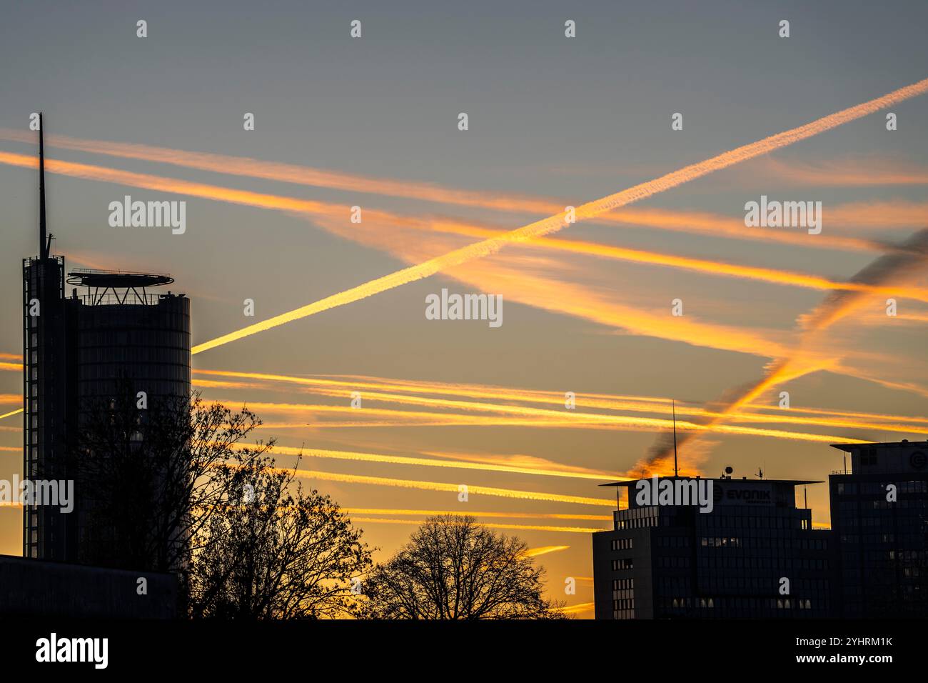 Traînées d'avions volant à haute altitude, ciel du soir, après le coucher du soleil Banque D'Images