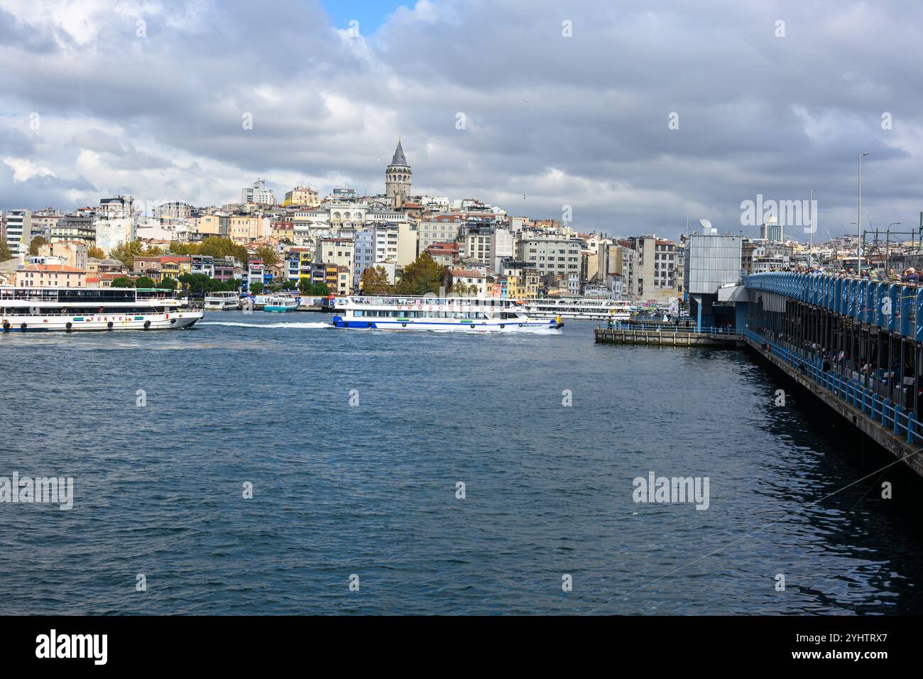 25/10/2024. Istanbul, Turquie. Le pont de Galata, enjambant la Corne d'Or. Il a été construit par la société de construction turque STFA à quelques mètres du pont précédent, entre Karaköy et Eminönü, et achevé en décembre 1994. Il s'agit d'un pont basculant de 490 m (1 610 ft) de long avec une portée principale de 80 m (260 ft). Le pont du pont est large de 42 m (138 pi) et comporte deux voies de circulation et une passerelle dans chaque direction. Les voies de tramway qui descendent au milieu permettent au tramway T1 de circuler de Bağcılar, dans la banlieue ouest, à Kabataş. En 2003, une série de restaurants ont été ajoutés Banque D'Images