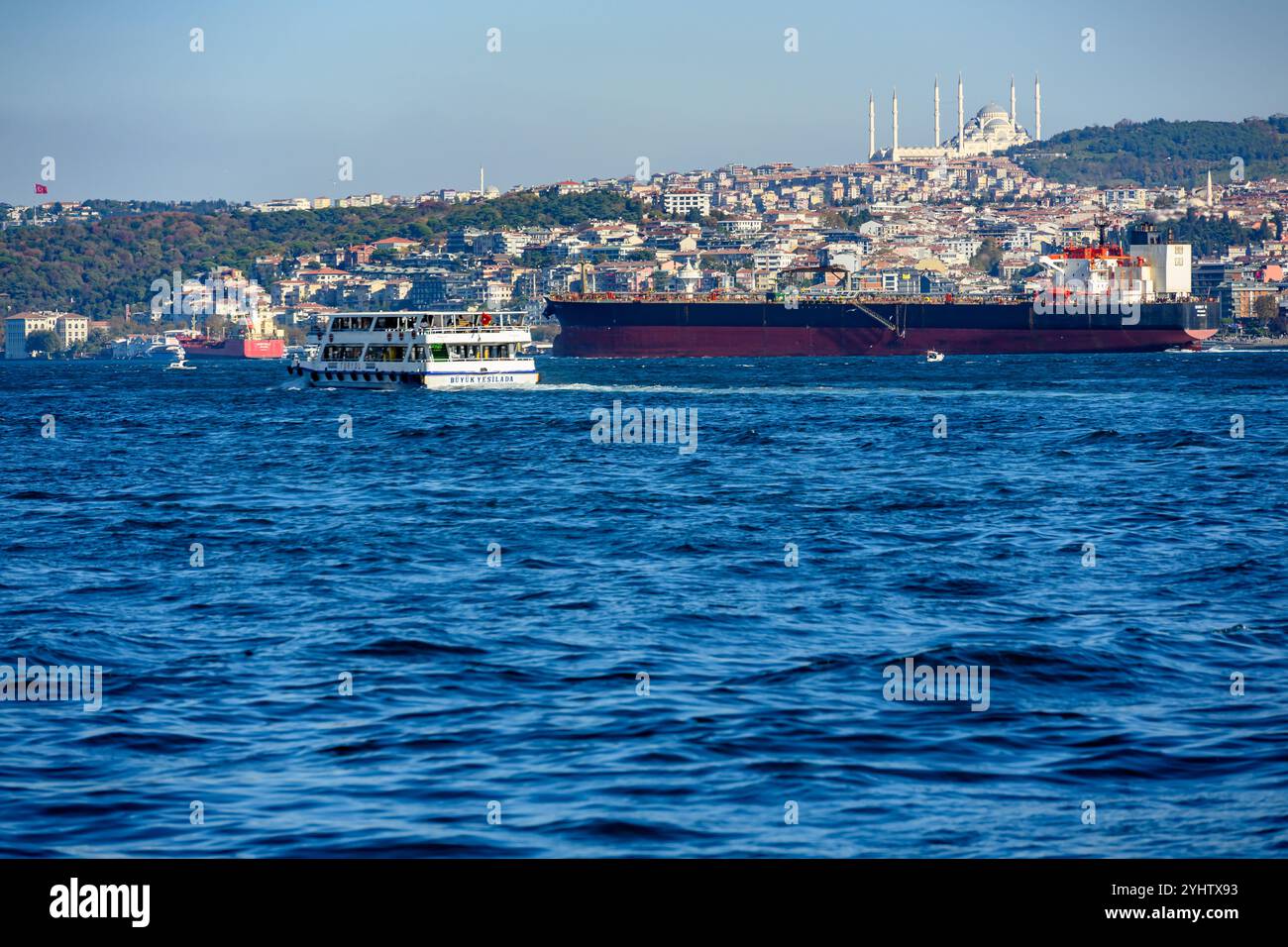 27/10/2024. Istanbul, Turquie. Un grand cargo remontant le Bosphotus en direction de la mer Noire pour le chargement de fret, avec un ferry de passagers se dirigeant vers le côté asiatique depuis Eminonou. Photo : © Simon Grosset Banque D'Images