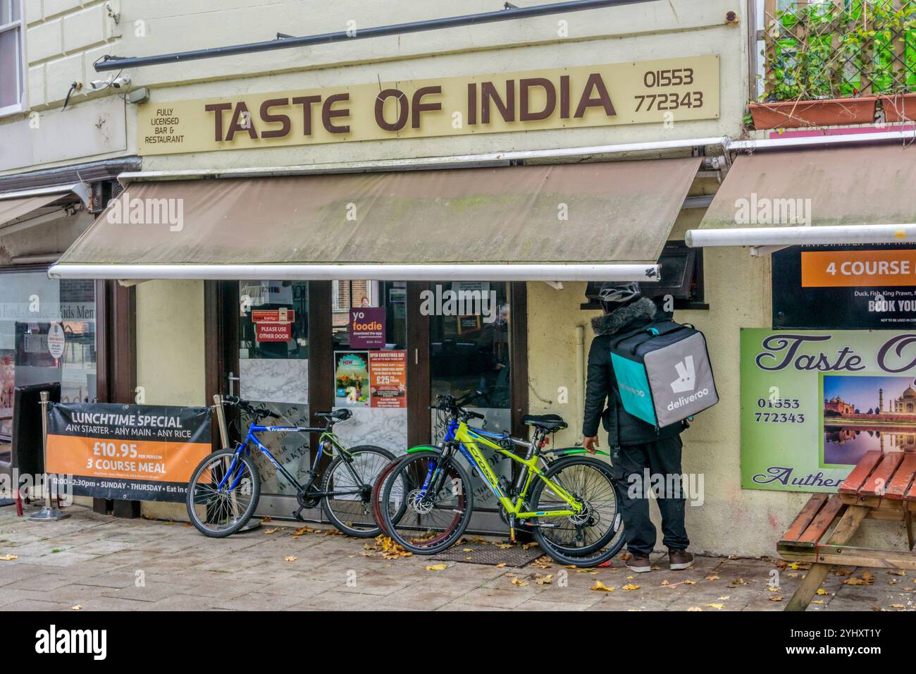 Un livreur de nourriture Deliveroo dans un restaurant indien à emporter à King's Lynn, Norfolk. Banque D'Images