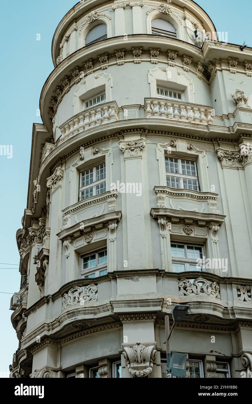 Élégant bâtiment d'angle avec une architecture classique contre un ciel bleu clair à Belgrade, Serbie. Parfait pour le design urbain, les voyages et le contenu historique. Photo de haute qualité Banque D'Images