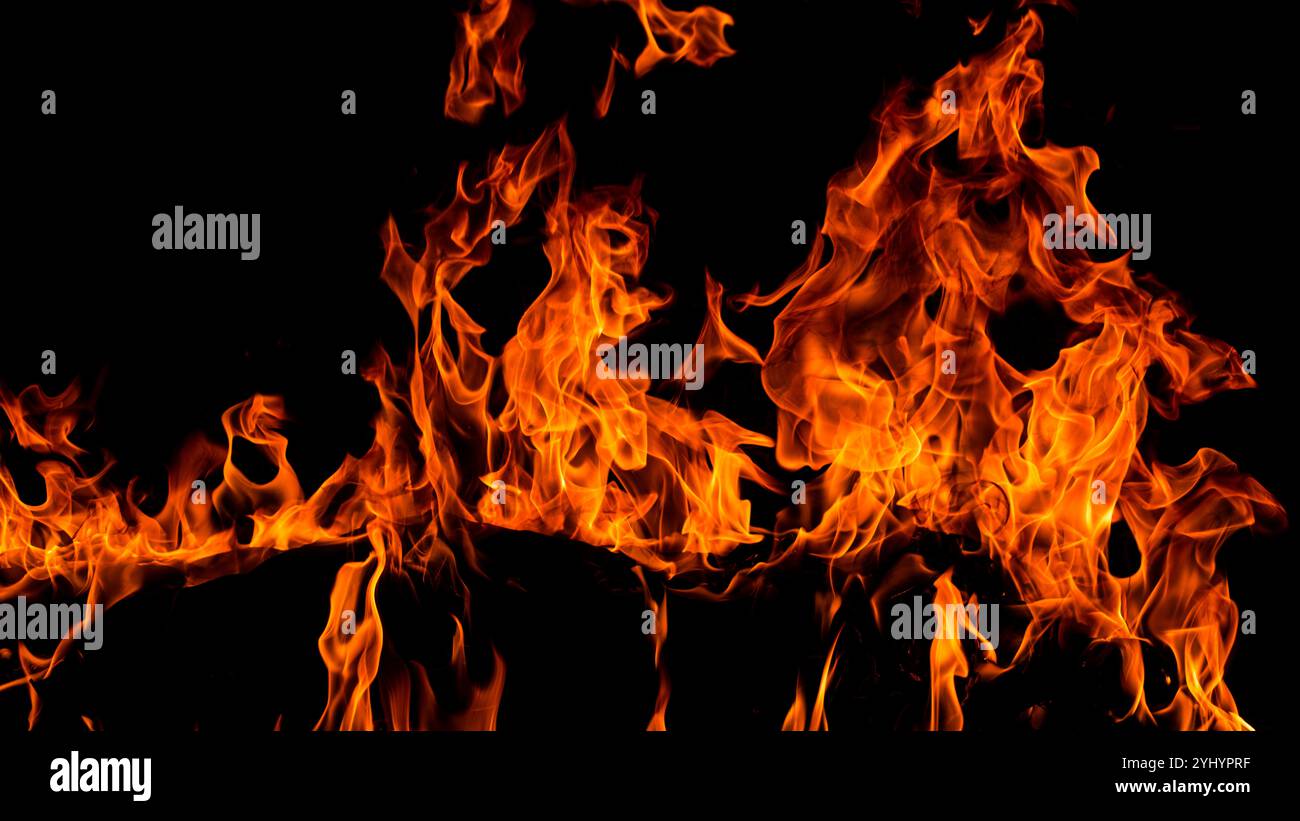 Flammes de feu sur fond noir. Fond d'étincelles de feu. Fond abstrait de flammes de feu sombres. Fond de flammes flammes flamboyantes. Banque D'Images