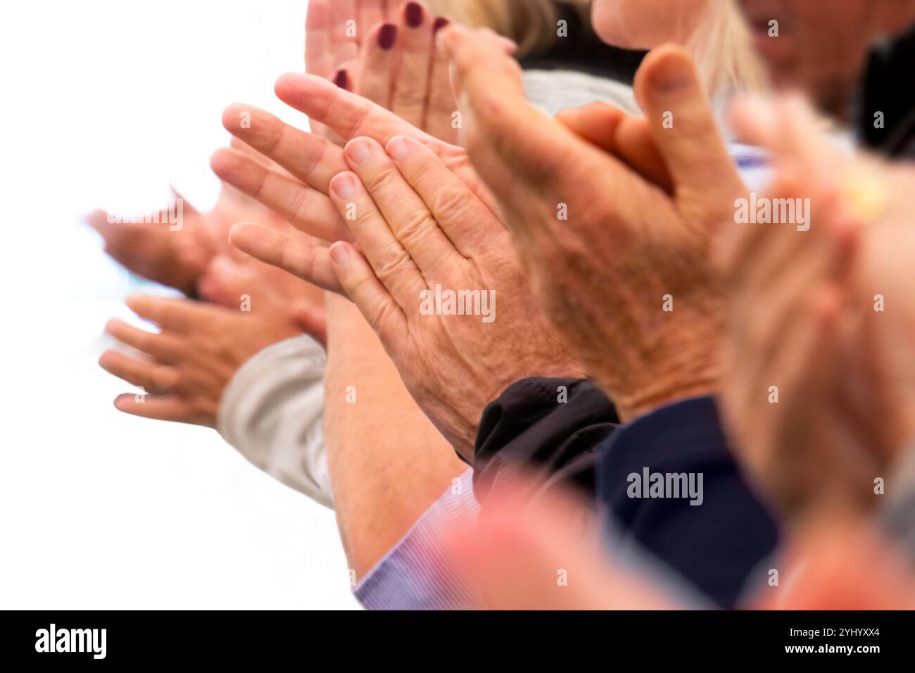 Applaudissements - mains applaudies d'un groupe de personnes dans une rangée sur fond blanc. Les adultes seniors anonymes reconnaissants applaudissent avec enthousiasme. Banque D'Images