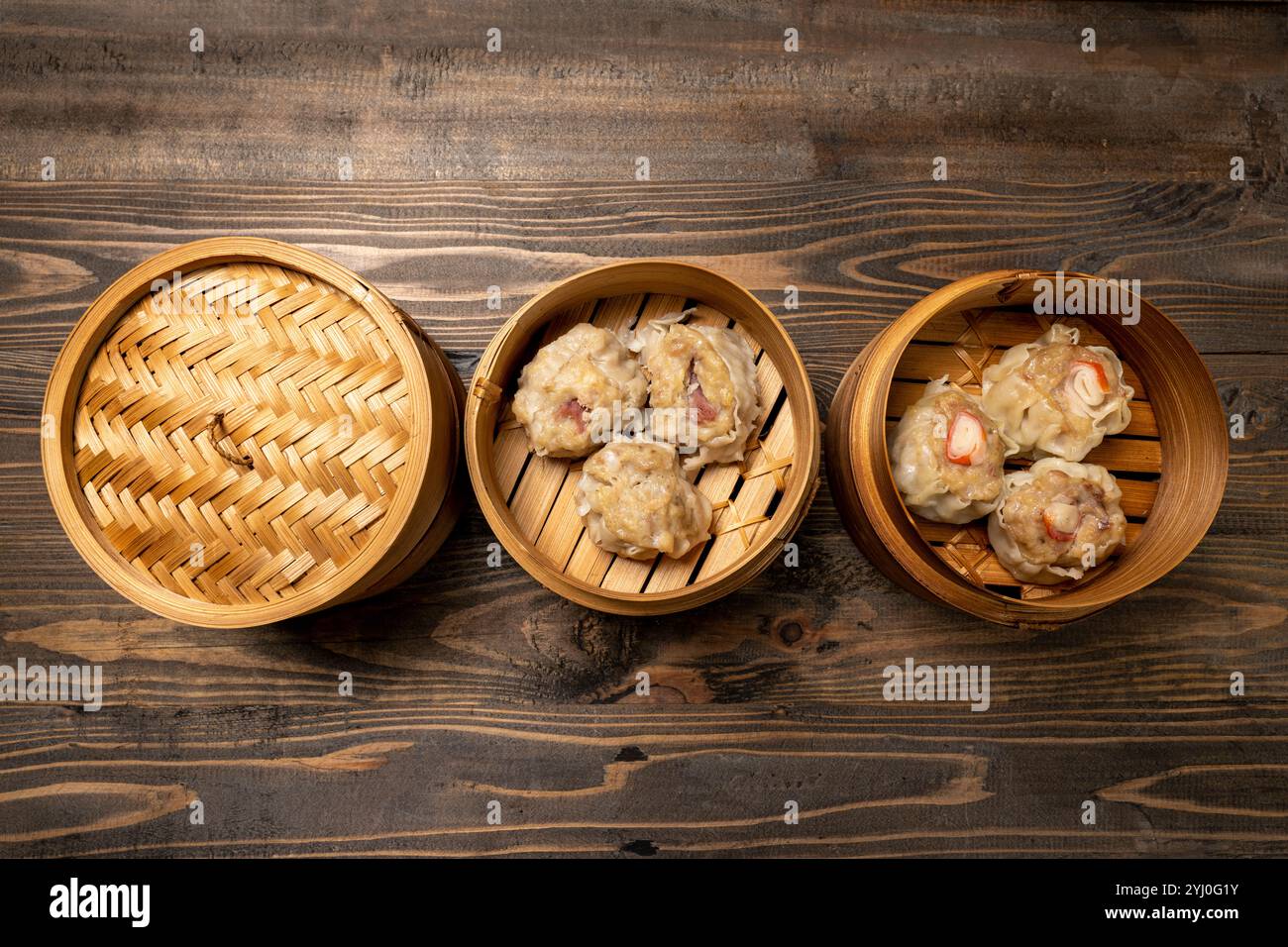 Boulettes de dim sum chinois assorties sur bol de panier en bois de bambou sur table en bois. Nourriture pour le petit déjeuner, le déjeuner ou le dîner. Décoration chinoise ou lunaire du nouvel an Banque D'Images