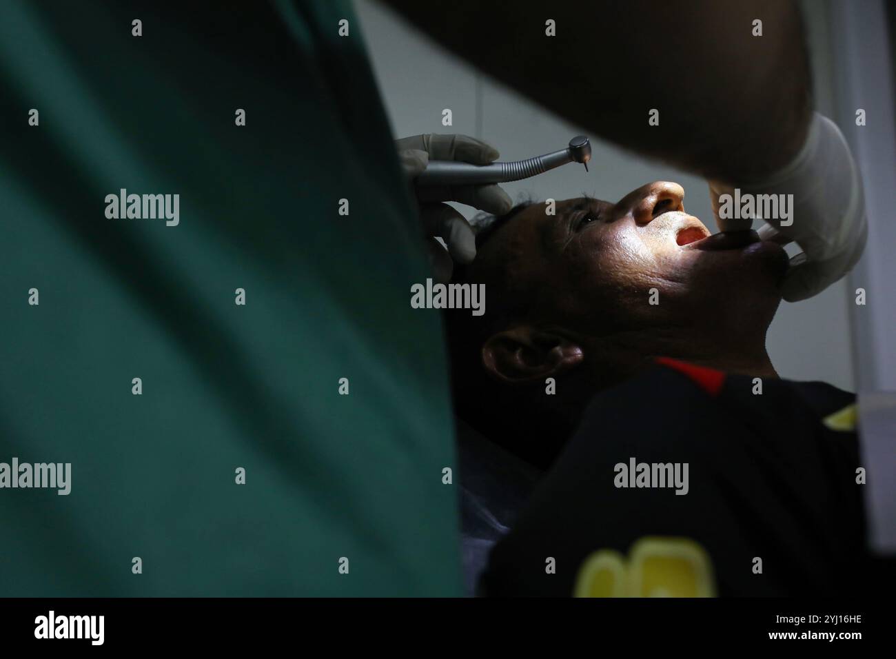 Un patient est soigné par Joao Paulo Pelagio Toneto, dentiste. A Monte-Alegre, au Brésil, au milieu de la forêt amazonienne, le bateau-hôpital du Pape François, fondé et géré par la Fraternité Saint François d’assise dans la Providence de Dieu, rencontre les habitants locaux pour pallier le manque d’infrastructures sanitaires dans une région marquée par l’exploitation minière et les effets du changement climatique. Banque D'Images