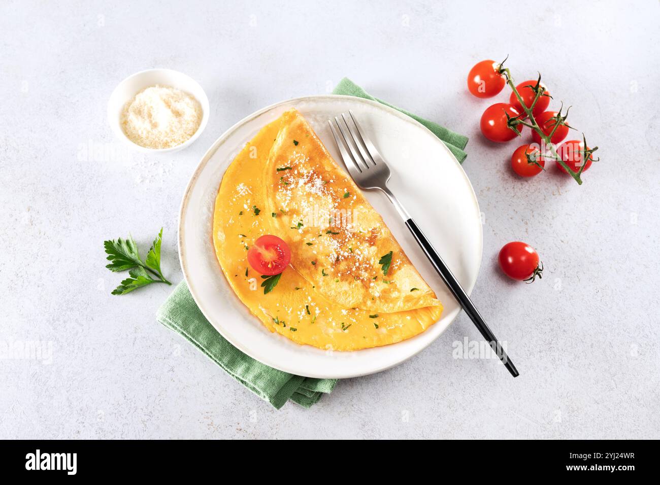 Omelette aux œufs avec fromage, tomate et persil sur fond blanc. Vue de dessus. Banque D'Images