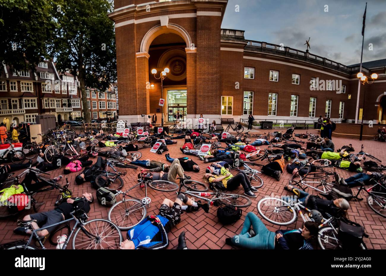 Londres, Royaume-Uni. 12 octobre 2017. Un homme tient une affiche écrite avec l'aide de sa fille de 8 ans lors de la veillée Die-In et protestation par Stop Killing Cyclists devant la mairie de Kensington & Chelsea après le meurtre par un poids lourd d'une jeune femme de 36 ans à Chelsea Bridge la semaine dernière, le deuxième cycliste tué par un poids lourd dans le quartier cette année. Kensington & Chelsea est l'un des pires arrondissements londoniens à s'opposer aux plans de voies cyclables protégées, de contournements cyclables d'arrêts de bus et de limites de vitesse de 20 km/h et n'a pas réussi à construire ne serait-ce qu'un mètre de voie cyclable protégée, forçant les cyclistes, y compris les enfants Banque D'Images