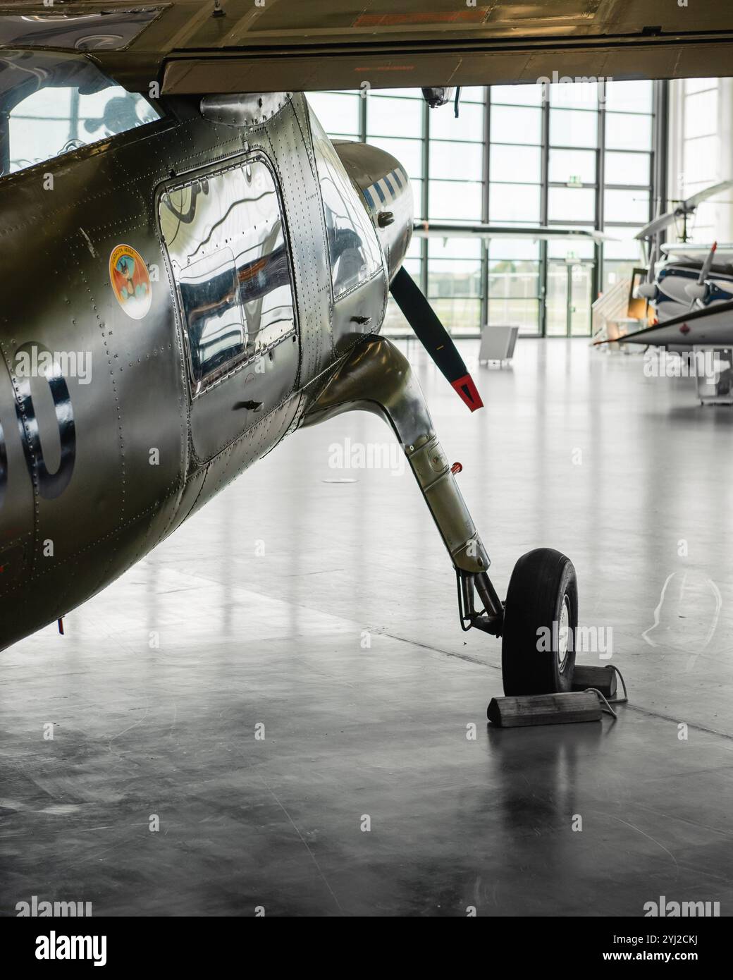 Sous une aile d'avion STOL. Vert militaire Dornier DO-27A-5 dans un hangar aéré. Banque D'Images