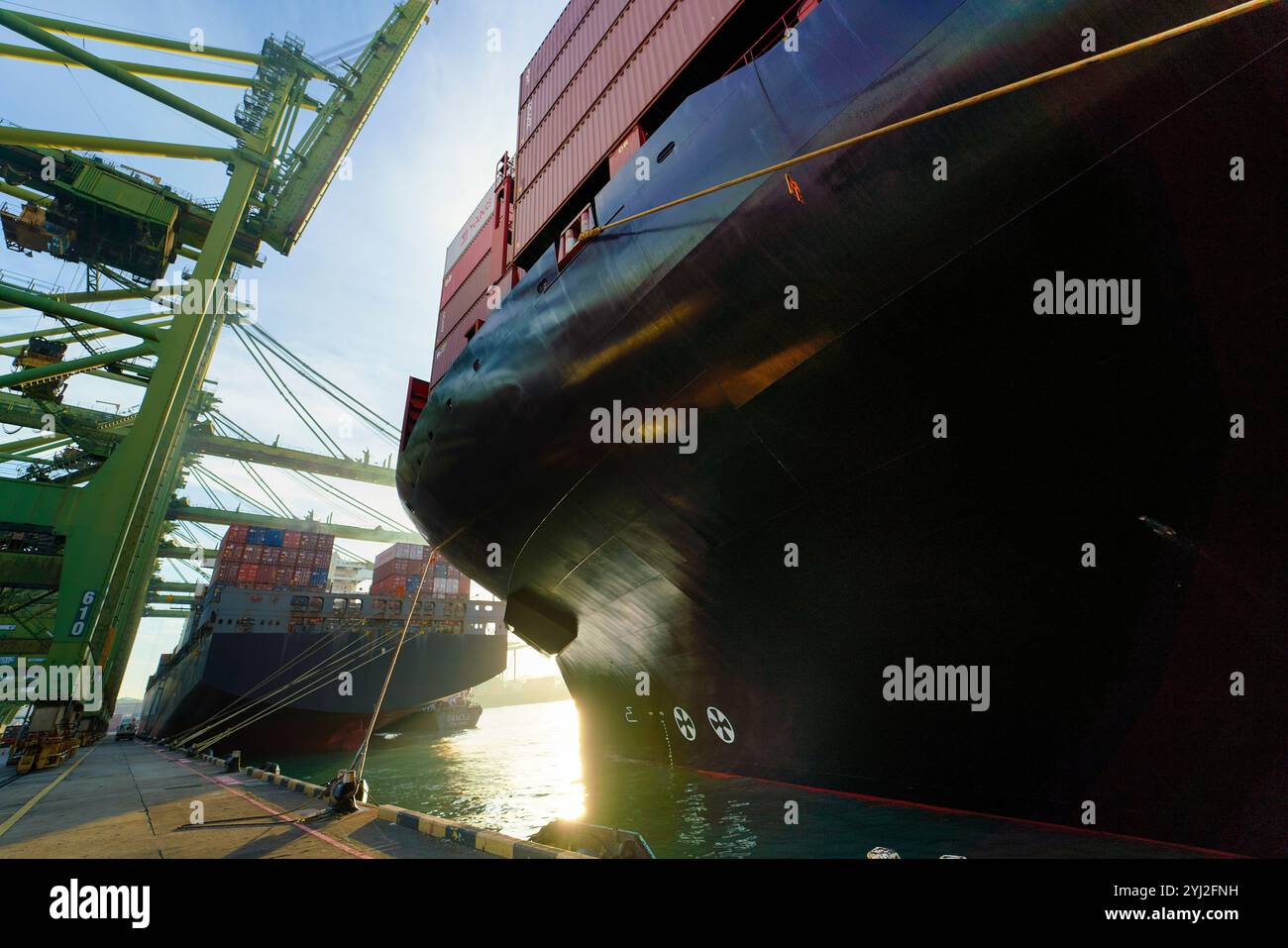 Sunset illumine un grand cargo chargé de conteneurs sur un quai commercial, Singapour Banque D'Images